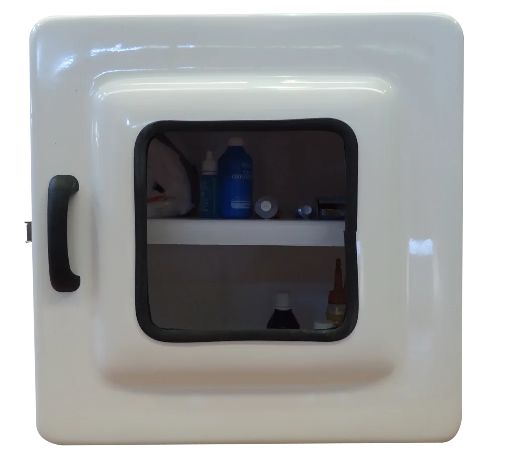 Foto de Imagem do Armário para Medicamentos Código 443B. A caixa é quadrada e profunda, na cor branca. Possui porta com visor transparente e fecho em aço inox. O interior revela espaço amplo com uma prateleira.