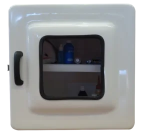 Imagem do Armário para Medicamentos Código 443B. A caixa é quadrada e profunda, na cor branca. Possui porta com visor transparente e fecho em aço inox. O interior revela espaço amplo com uma prateleira.